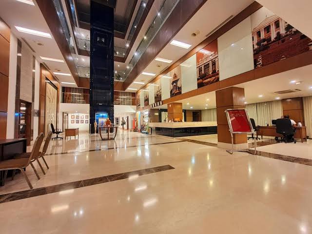 Boutique office atrium lobby with a central glass elevator shaft